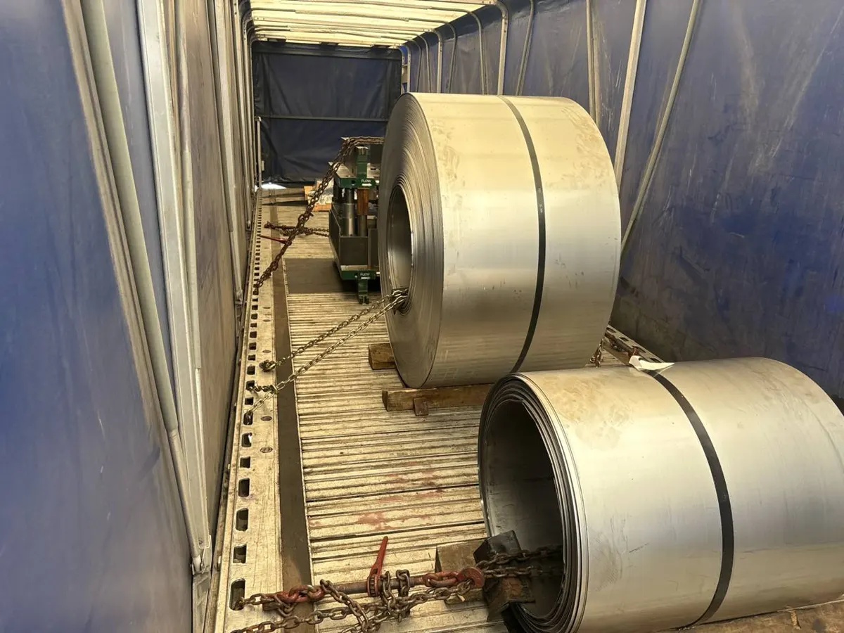 Steel coils chained inside a Conestoga with the tarp closed