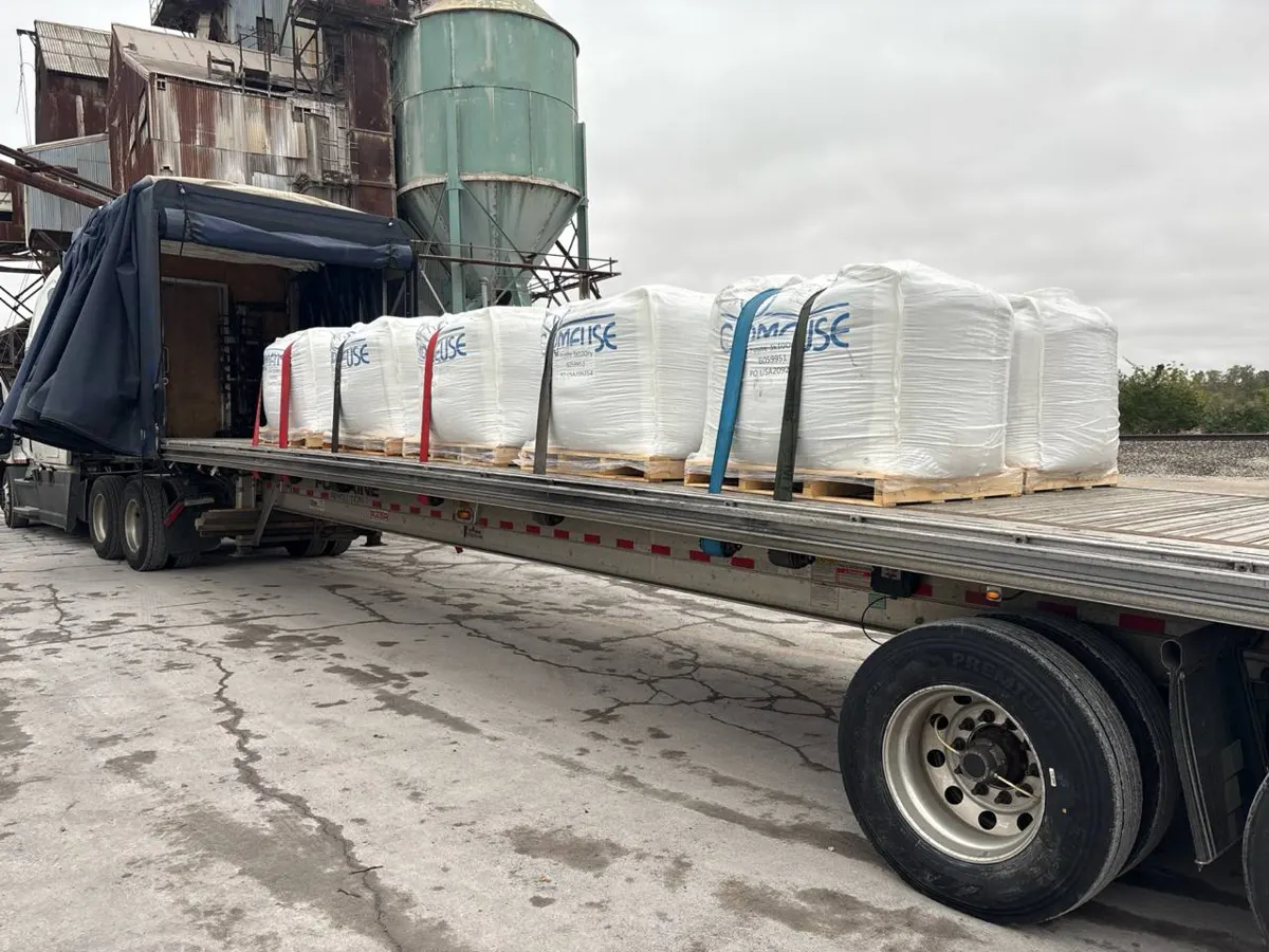 Conestoga with the tarp rolled back, loaded with strapped bulk bags